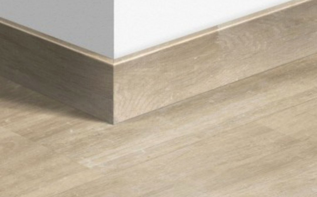 Rodapié de madera con canto superior redondeado sobre tarima clara