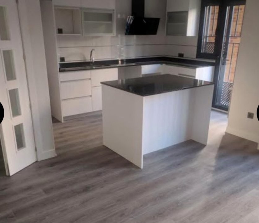 Cocina con isla y tarima laminada en tono ceniza